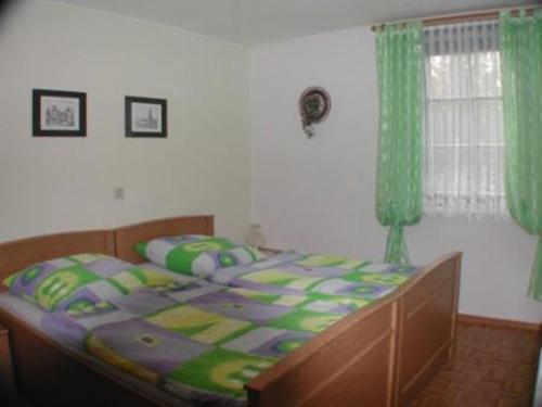 sypialnia z dużym łóżkiem z zielonymi zasłonami w obiekcie Haus Feldmühle w mieście Bad Frankenhausen