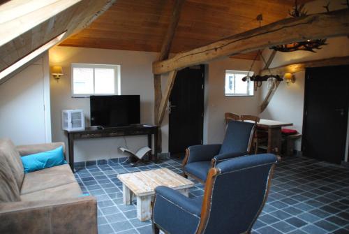 a living room with a couch and chairs and a table at Boerensuite, heerlijk verblijf in het Karschop in Riel