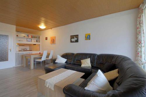 a living room with a leather couch and a table at Apartment 527 in Hohegeiß