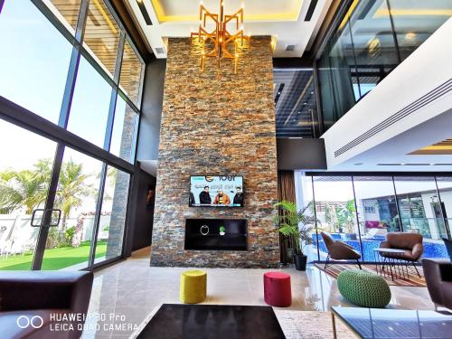 a lobby with a brick fireplace and a chandelier at G R A N D C H A L E T in Salalah