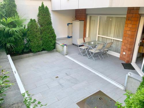 eine Terrasse mit einem Tisch und Stühlen vor einem Gebäude in der Unterkunft Apartment Locarno-Lido in Locarno