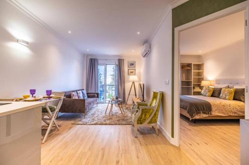 Funchal Center Apartment II في فونشال: غرفة نوم مع سرير وغرفة معيشة