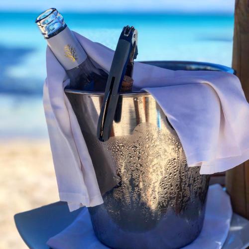 a bottle of wine in a bucket on the beach at Club Esse Roccaruja in Stintino