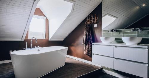 ein Badezimmer mit einer weißen Badewanne und 2 Waschbecken in der Unterkunft Terra Boutique Hotel Curaçao in Willemstad