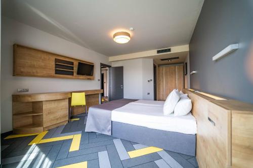 a hotel room with a bed and a desk at HVD Club Bor Ultra All Inclusive - Private Beach & Free parking in Sunny Beach