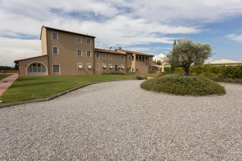 a house with a gravel driveway in front of it at Resort Casale Le Torri in Ponsacco