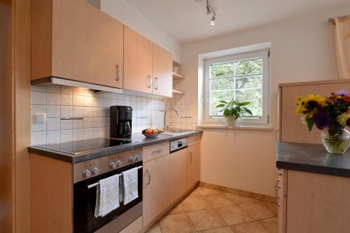 een keuken met een fornuis, een wastafel en een raam bij Appartement Christine in Brixen im Thale