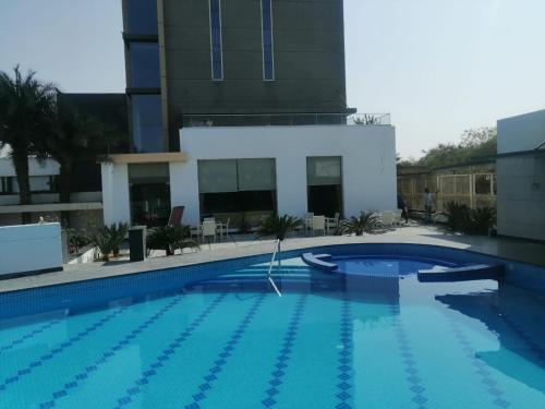 a large swimming pool in front of a building at Hotel Kasturi Orchid in Pāl