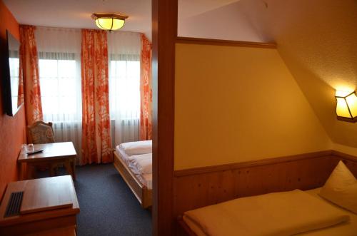 a small room with a bed and a window at Hotel Bergwirt in Herrieden