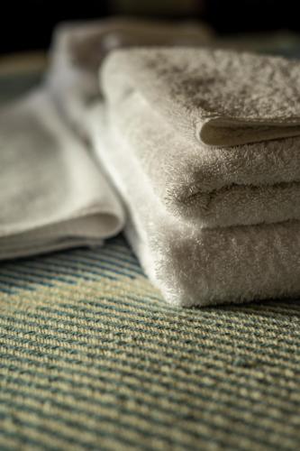 a pile of towels sitting on top of a bed at Western Isles Hotel in Tobermory