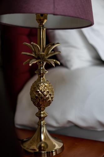 a gold lamp with a pineapple on a table at Western Isles Hotel in Tobermory