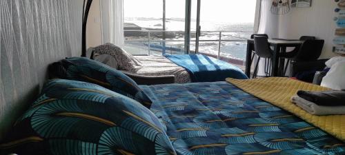 een slaapkamer met een bed en uitzicht op de oceaan bij Studio face à la mer in Concarneau