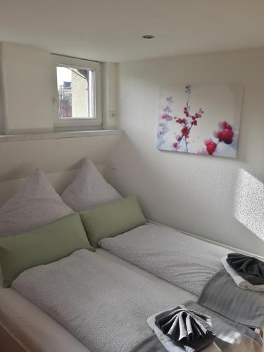 a bed in a small room with a window at Ferienwohnung Katrin - nahe Chemnitz in Limbach-Oberfrohna