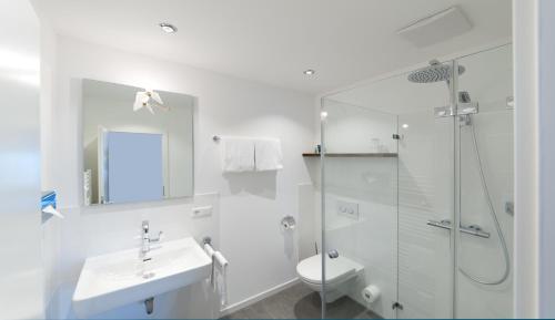 uma casa de banho com um chuveiro, um lavatório e um WC. em Hotel Engel - Lindauer Bier und Weinstube em Lindau