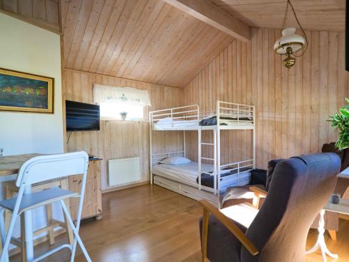 a room with two bunk beds and a table at Rosenborgs Friluftspensionats stugor med kök in Färjestaden