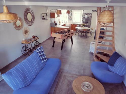 un salon avec un canapé bleu et une table dans l'établissement Chez Constant, à Hargnies