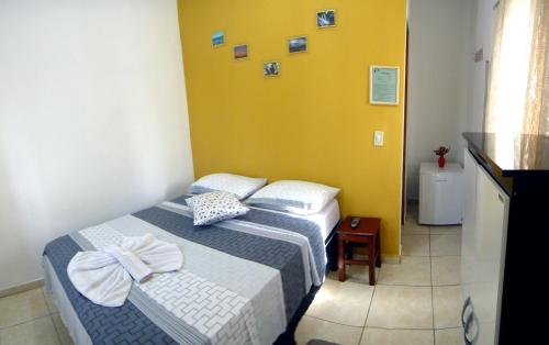 1 dormitorio con 2 camas y pared amarilla en Pousada Jubaia, en Bonito