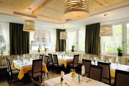 a dining room with tables and chairs and windows at Posthotel Lechtal, Arlberg in Holzgau