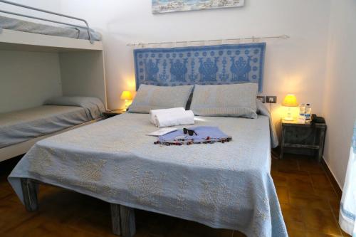 Schlafzimmer mit einem großen Bett mit blauem Kopfteil in der Unterkunft Club Esse Sporting in Stintino