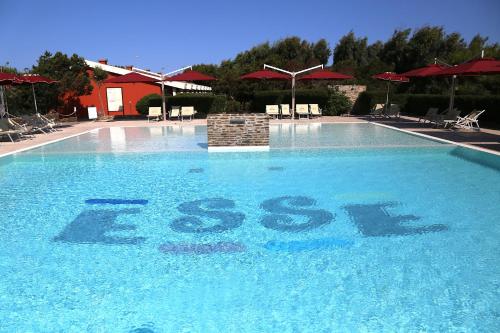 a swimming pool with the word escape written in the water at Club Esse Sporting in Stintino