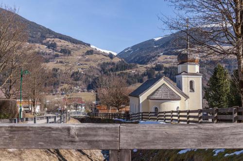 a small white church with a mountain in the background at Ferienwohnung Brugger 4 Personen in Kaltenbach