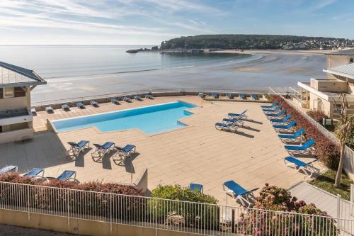 - une vue sur une plage avec des chaises et une piscine dans l'établissement Appartement cosy les pieds dans l’eau, vue mer exceptionnelle, à Crozon