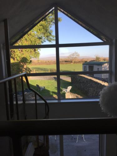 a window looking out at a view of a field at The Burren Barn in Tubber