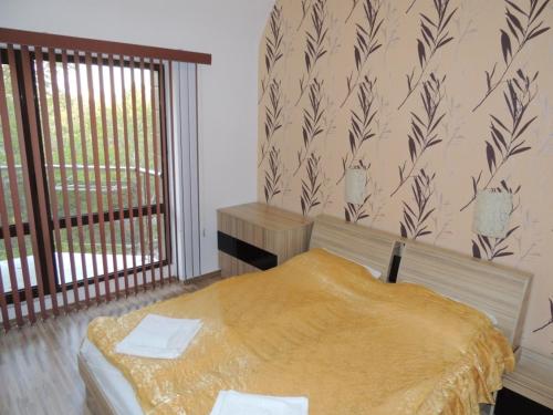 a bedroom with a bed in a room with a window at Apartments in Relax Complex Fantasy in Hisarya