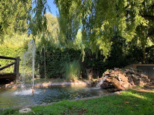 a pond with a fountain in a garden at Pilgrim's Rest - Descanso del Peregrino in Chacras de Coria