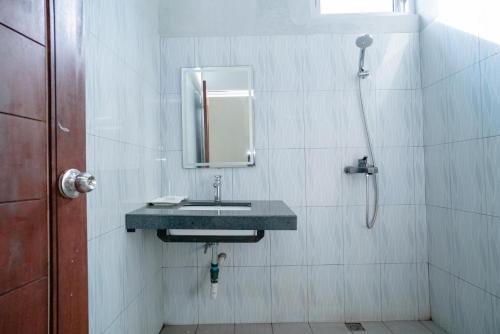 y baño con lavabo y ducha. en RedDoorz @ Jalan Pendidikan Mataram, en Tanjungkarang