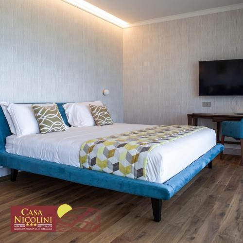 a bedroom with a bed with a tv on the wall at Casa Nicolini in Barbaresco