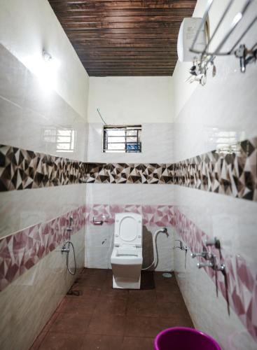 a bathroom with a toilet and a sink at Viraz Valley in Gokarna