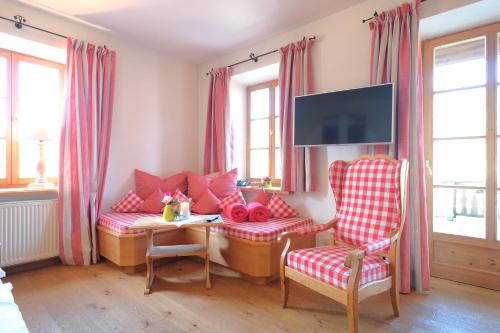 a living room with a couch and a table and chairs at Hotel Maier zum Kirschner in Rottach-Egern