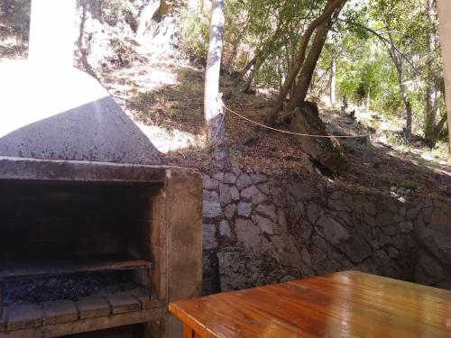 una chimenea de piedra con una mesa de madera junto a ella en Tu Casa en San Martín de los Andes en San Martín de los Andes
