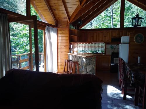 uma sala de estar de um chalé com uma cozinha e uma mesa em Tu Casa en San Martín de los Andes em San Martín de los Andes