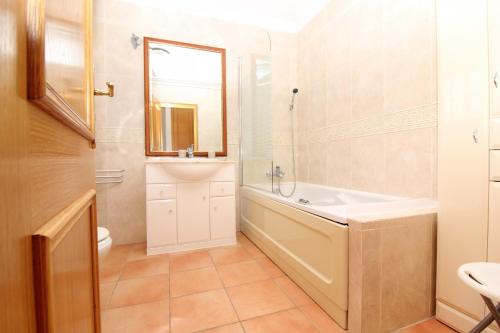 W łazience znajduje się wanna, umywalka i lustro. w obiekcie Villa Martina - São Rafael - Albufeira w Albufeirze
