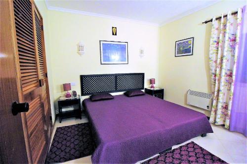 阿爾布費拉的住宿－Bellavista Center - Albufeira，一间卧室,在房间内配有一张紫色的床