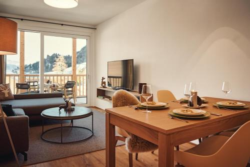 a living room with a table and a couch at die Tauplitz Lodges - Wasserfall Lodge C4 by AA Holiday Homes in Tauplitz