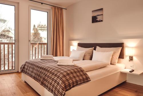 een slaapkamer met een groot bed en een groot raam bij die Tauplitz Lodges - Bergblick Lodge B6 by AA Holiday Homes in Tauplitz