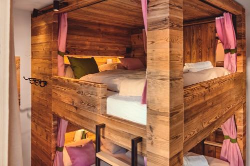 a bedroom with two beds in a wooden room at Die Tauplitz Lodges - Penthouse Grimming D7-1 by AA Holiday Homes in Tauplitz