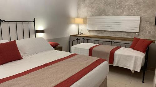 a bedroom with two beds with red and white sheets at Dimora del Leone Gaeta in Gaeta