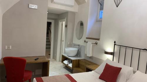 a bedroom with a bed and a bathroom with a sink at Dimora del Leone Gaeta in Gaeta