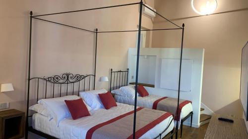 a bedroom with two beds and a canopy bed at Dimora del Leone Gaeta in Gaeta