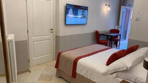 a bedroom with a bed and a tv on the wall at Dimora del Leone Gaeta in Gaeta