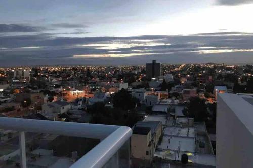 - une vue sur les toits de la ville la nuit dans l'établissement Bonito Departamento a metros del MAR ., à Puerto Madryn