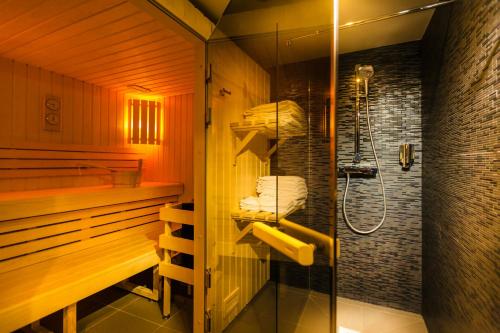 y baño con ducha y cabina de ducha acristalada. en Helussi Hôtel en París