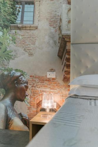 a lamp sitting on a table next to a bed at Hotel Giulietta e Romeo ***S in Verona