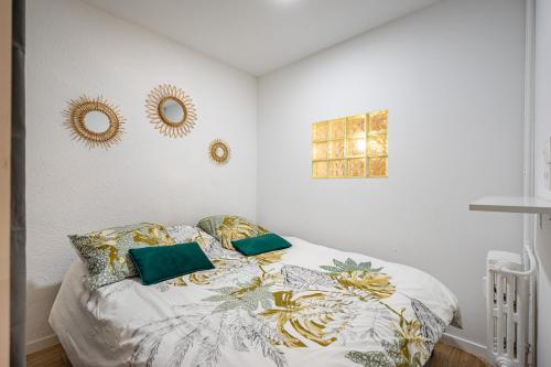 - une chambre dotée d'un lit avec des oreillers jaunes et verts dans l'établissement T2 Plage Catalans-Vieux port, à Marseille