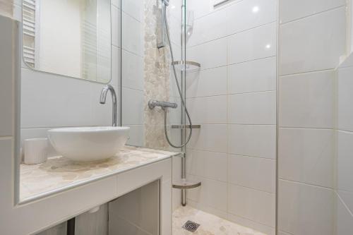 une salle de bain blanche avec un lavabo et une douche dans l'établissement T2 Plage Catalans-Vieux port, à Marseille