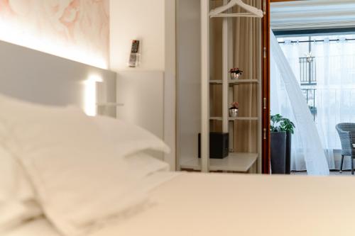 a bedroom with a white bed and a mirror at Hotel Giulietta e Romeo ***S in Verona